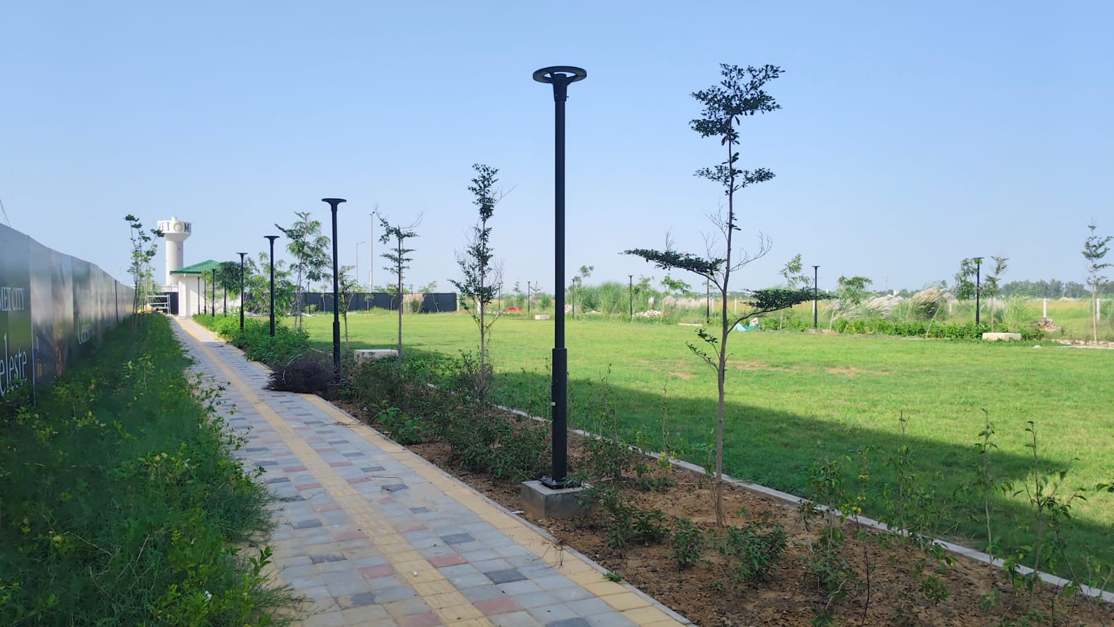 Tree-lined pedestrian path next to MET City Celeste